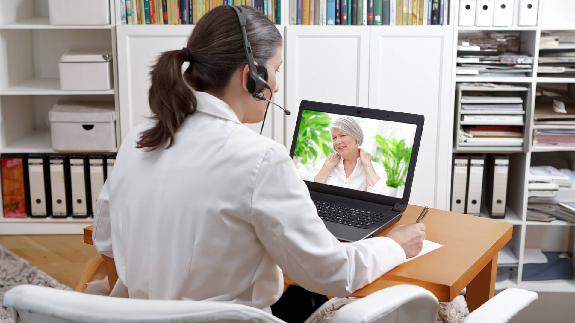 a doctor is talking to a patient on a video call using her laptop
